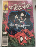 Comic book cover featuring Spider-Man and Venom with a signature on a white background